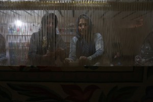 یکی از بافنده ها در حال سرکش کردن و دیگری در حال گره زدن با چاقو 